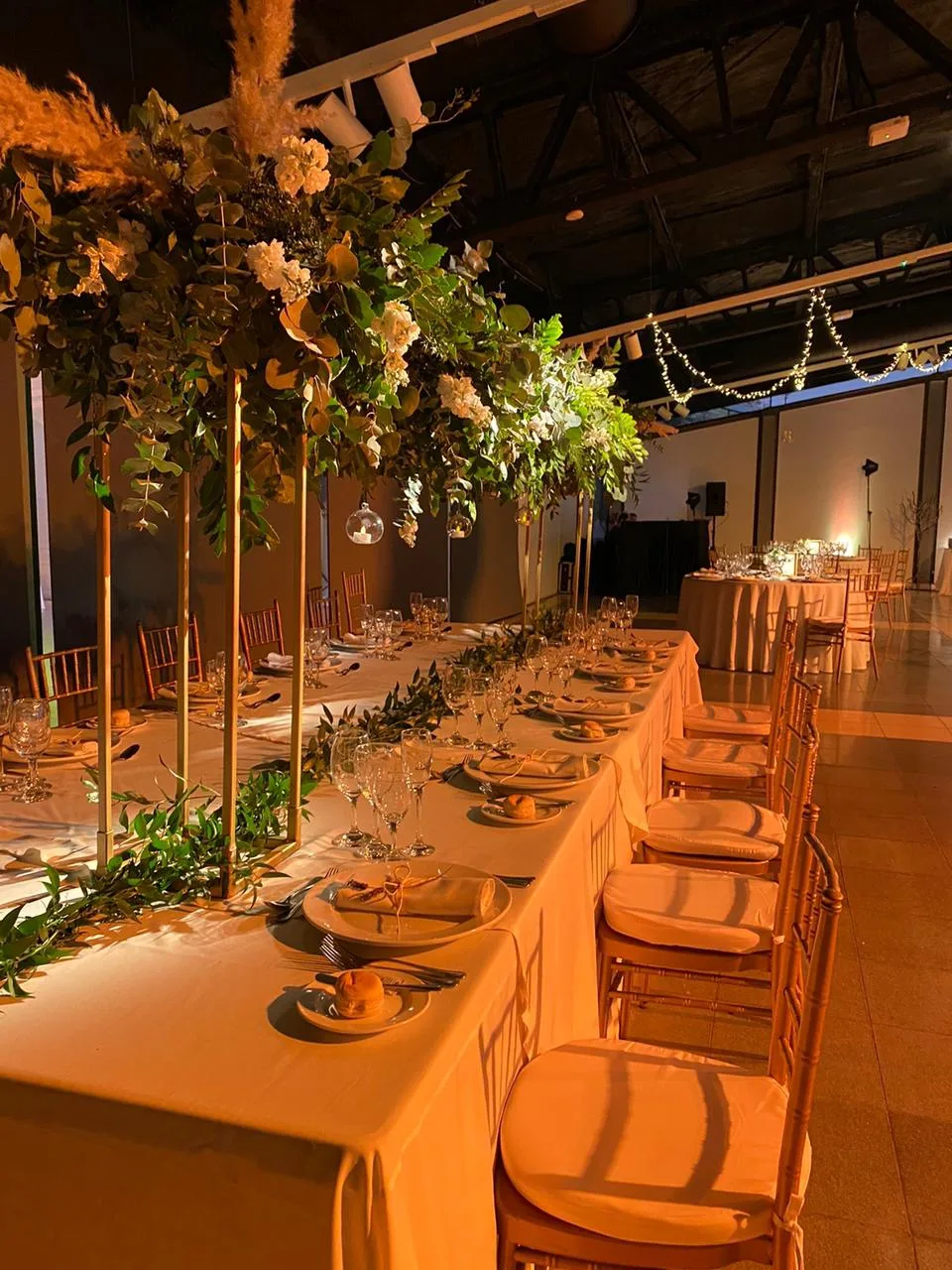 Mesa larga montada con flores y velas para un matrimonio en Centro La Reina